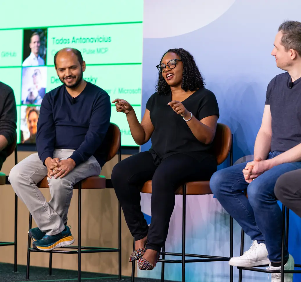 Speakers seated onstage during a panel discussion at GitHub Universe.